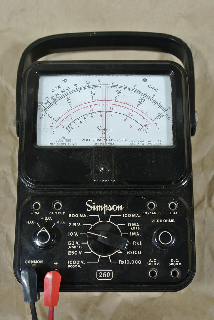 Figure 4 — 4 — A vintage Simpson 260 Series 5 volt-ohm-milliammeter — the archetypal analog multimeter the collected build imitates in its engraved face — showing the long mirror-backed scale, the ta…